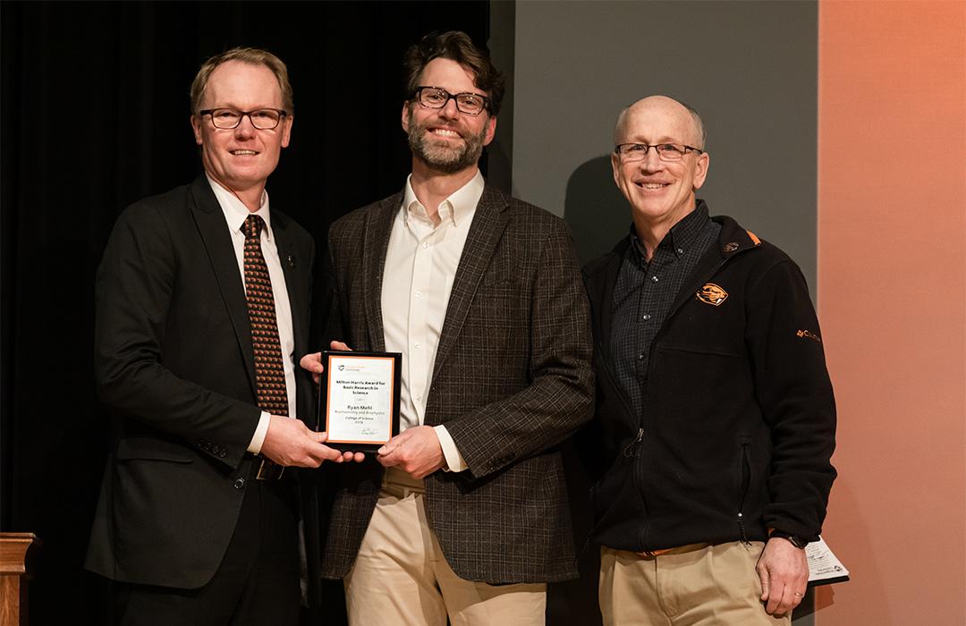 Ryan Mehl receiving award on stage with colleagues