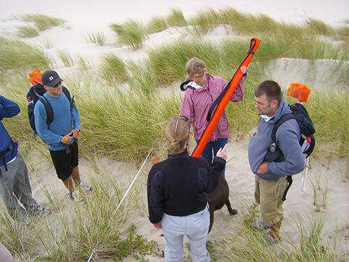 Sally Hacker working with students on the beach
