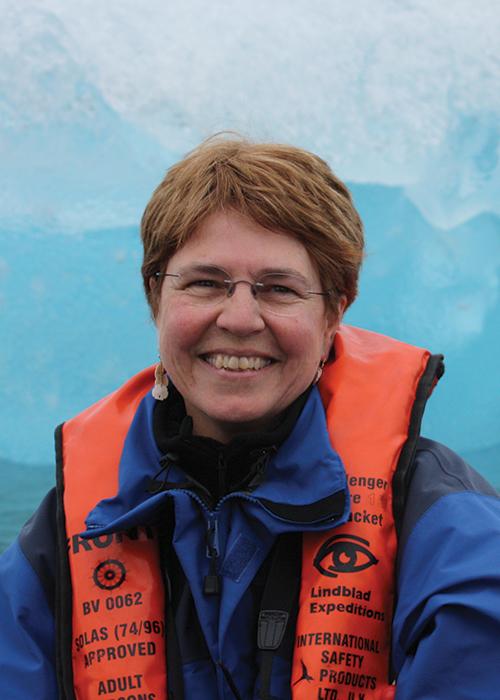 Jane Lubchenco in front of ice glacier wearing life jacket