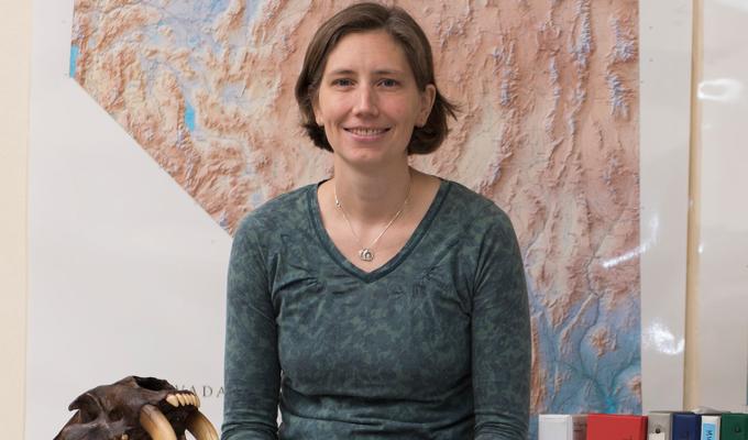 Rebecca Terry sitting in office space in front of map