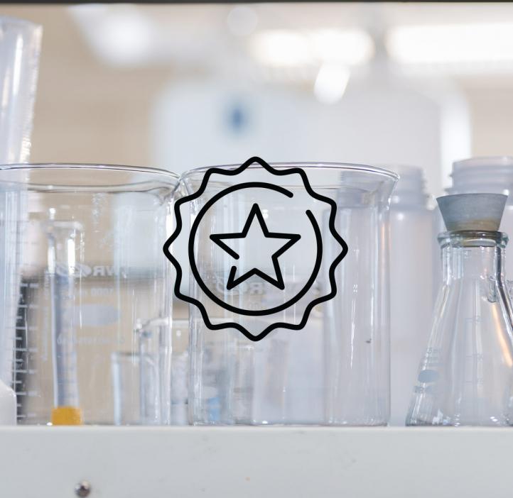 A star badge icon above an image of beakers and lab equipment sitting on a lab table.
